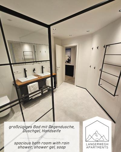 a bathroom with two sinks and a mirror at Langerwegh Apartments AP2 in Fieberbrunn