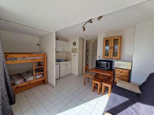 une chambre avec une cuisine et une chambre avec des lits superposés dans l'établissement Appartement avec piscine, plage à proximité, animaux et parking, climatisation - FR-1-387-212, à Marseillan
