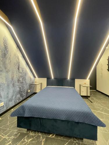 a bedroom with a bed in a room with paintings at Blue Love in Wrocław