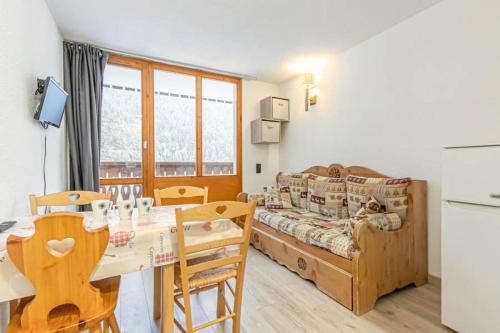 a living room with a table and a couch at Studio 4 personnes cœur station in Valfréjus