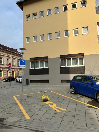 una macchina blu parcheggiata in un parcheggio di fronte a un edificio di Apartment Lola Brand New, Self check-in 0-24, Free parking a Karlovac