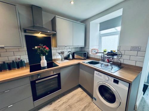 a kitchen with a sink and a washing machine at Keekle Cottage - 2 Bedrooms - Sleeps 4 in Cleator Moor