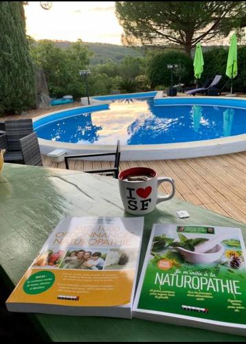 a table with a magazine and a cup of coffee at La Villa du Menhir Gîte in Bize-Minervois