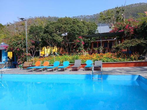 a large swimming pool with chairs at Catba Papillon Garden Bungalows & Resort in Cat Ba