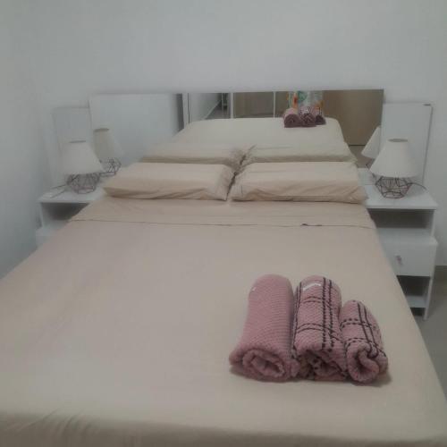 two beds with towels on them in a bedroom at Suite Versailles in Cuiabá