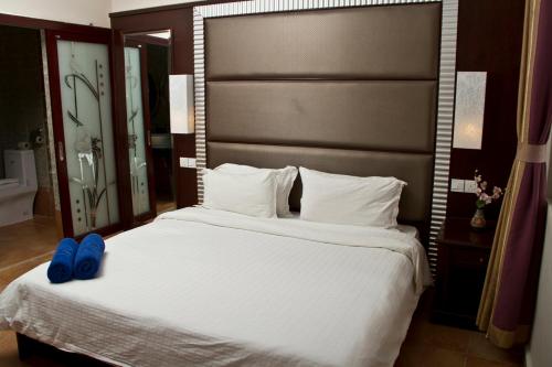 a bedroom with a large bed with blue shoes on it at Beringgis Beach Resort & Spa in Papar