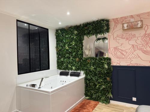 a bathroom with a green wall with a bath tub at Le Rom'Antik in Noyal-Pontivy