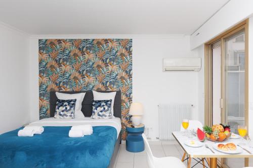 - une chambre avec un lit bleu et une table dans l'établissement Bleu Croisette YourHostHelper, à Cannes
