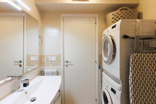 une salle de bain avec une machine à laver et un lavabo dans l'établissement Bleu Croisette YourHostHelper, à Cannes