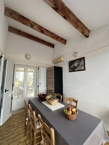 - une salle à manger avec une table, des chaises et des fruits dans l'établissement Villa Santa Rita, à Lucciana