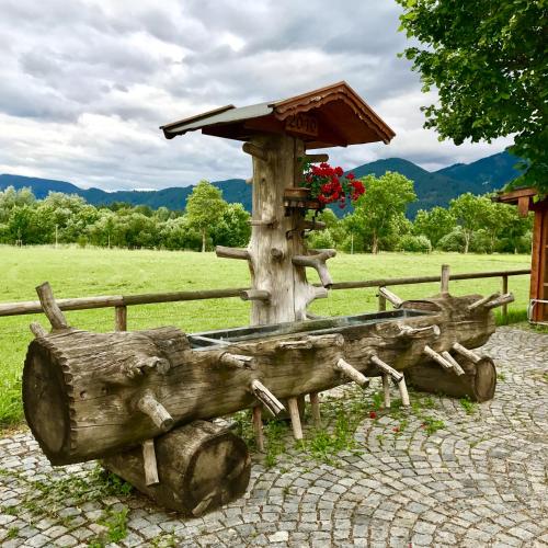a statue of a wooden boat next to a fence at Alpenglück de Luxe Ferienwohnung am Forggensee in Schwangau