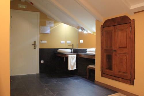 カカベロスにあるHostal Siglo XIXのバスルーム(シンク、木製のドア付)