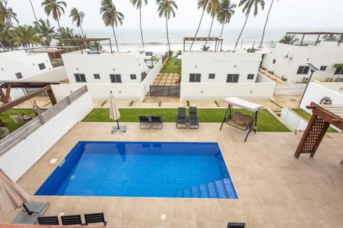 an aerial view of a house with a swimming pool and the ocean at Tills Beach Resort in Fetta