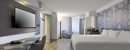a hotel room with a bed and a flat screen tv at DoubleTree by Hilton Ottawa Downtown in Ottawa