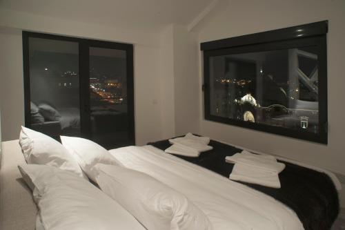 a white bed with white pillows and a mirror at Apartments Villa Savamala in Belgrade