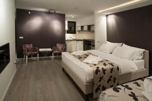 a bedroom with a large bed and a kitchen at Apartments Villa Savamala in Belgrade
