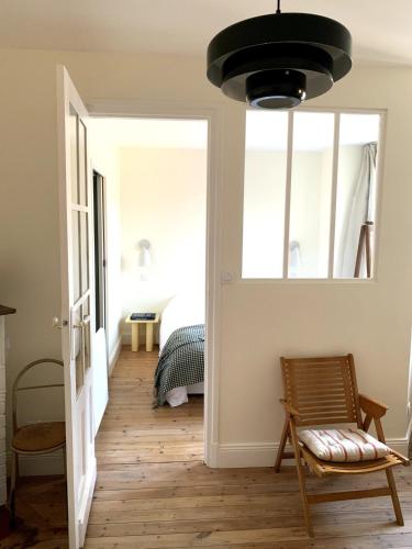 Cette chambre comprend un lit et une lampe pendant. dans l'établissement Astrée, Appartement 2-4 pers hyper-centre le touquet, à Le Touquet-Paris-Plage