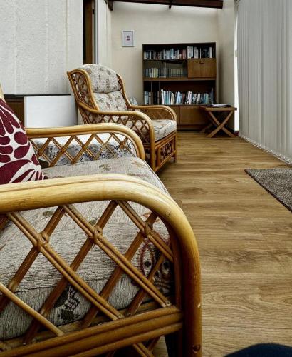 a living room with two chairs and a book shelf at Airyolland in Newton Stewart