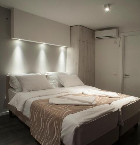 a large bed with white sheets and pillows on it at Apartments Villa Savamala in Belgrade