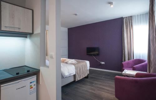 a hotel room with a bed and a purple wall at Apartments Villa Savamala in Belgrade