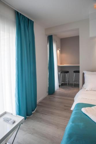 a bedroom with blue curtains and a bed and a table at Apartments Villa Savamala in Belgrade