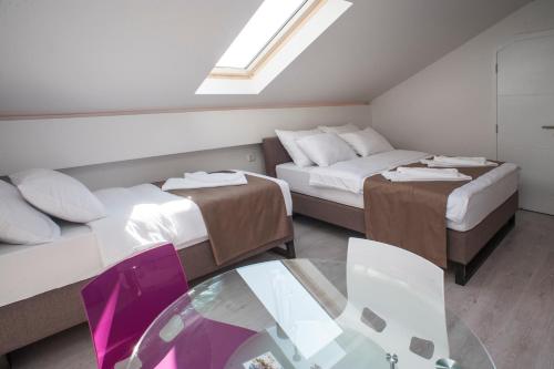 a small room with two beds and a glass table at Apartments Villa Savamala in Belgrade