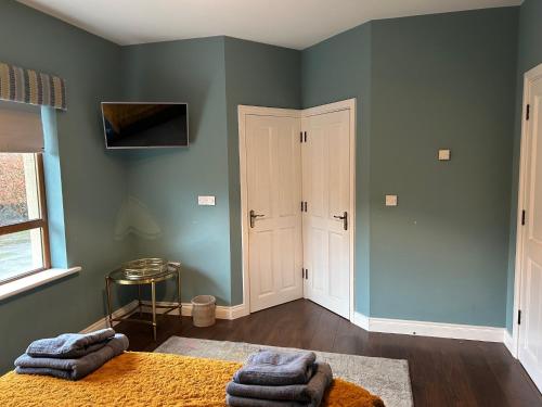 a room with green walls and a bed with towels at Castletown Carlow in Carlow