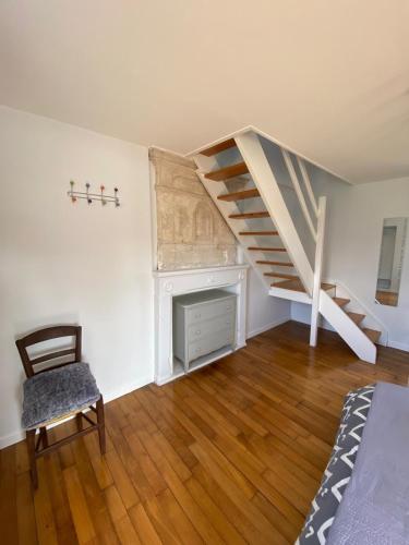 un salon avec un escalier et une chaise dans l'établissement Maison de Bourg, à Hermanville-sur-Mer