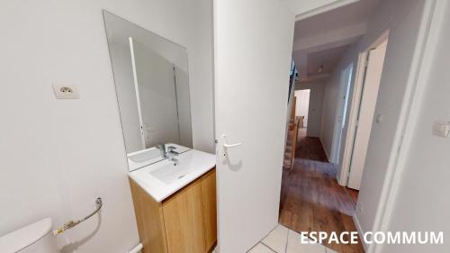 une salle de bain avec un lavabo et un miroir dans l'établissement Coty - chambre 1, au Havre