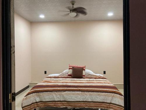 a bedroom with a bed with a ceiling fan at Vacacional Abril in Juayúa
