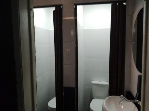 a bathroom with a white toilet and a sink at Hotel Capital HEU in Bogotá