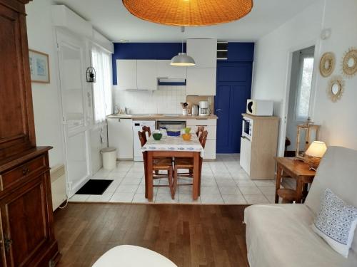 une cuisine et un salon avec une table et des chaises dans l'établissement gite notre désir 100 m de la mer, à Jullouville