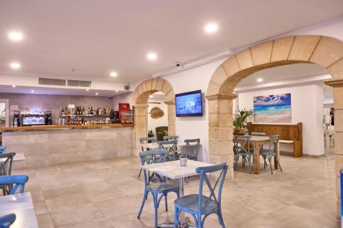 a restaurant with tables and chairs and a bar at INNER Hotel Rupit "Adults Only" in Cala d´Or