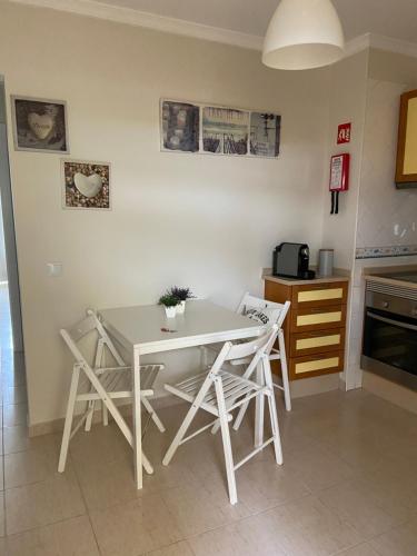 a kitchen with a table and chairs in a room at Moura 11 in Vilamoura