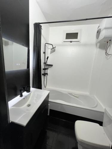 a white bathroom with a sink and a toilet at Le spacieux bis in Dakar