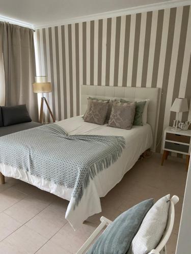 a bedroom with a bed and a striped wall at Moura 11 in Vilamoura