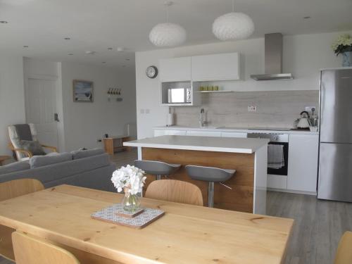 eine Küche und ein Wohnzimmer mit einem Holztisch, einer Küche und einem sidx-Tisch in der Unterkunft Beautiful 2 bed apartment with stunning sea views in Woolacombe