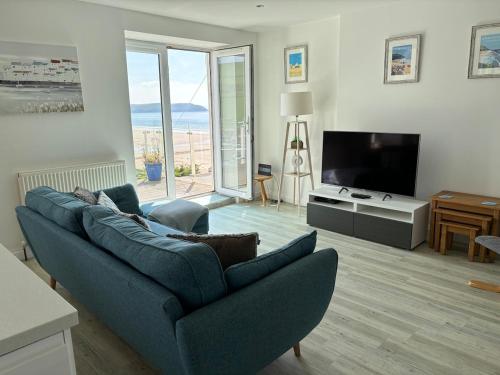 ein Wohnzimmer mit einer blauen Couch und einem Fernseher in der Unterkunft Beautiful 2 bed apartment with stunning sea views in Woolacombe