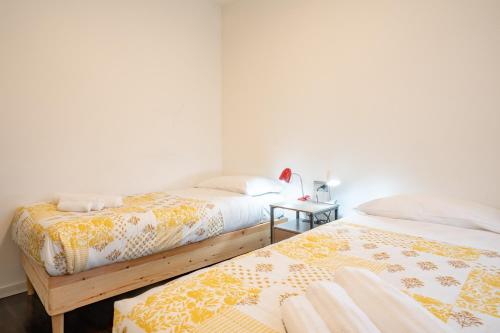 two beds sitting next to each other in a room at Authentic yet modern retreat in Lecco center in Lecco