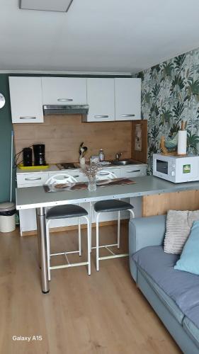 - une cuisine avec une table et un canapé dans une chambre dans l'établissement Mer et campagne, à Quend