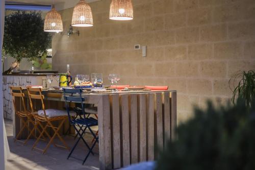a table in a kitchen with chairs and lights at Nilu al Mare - Villa pool & sea Monopoli in Monopoli