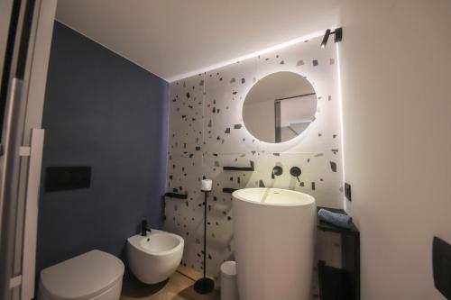 a bathroom with a sink and a toilet and a mirror at Nilu al Mare - Villa pool & sea Monopoli in Monopoli