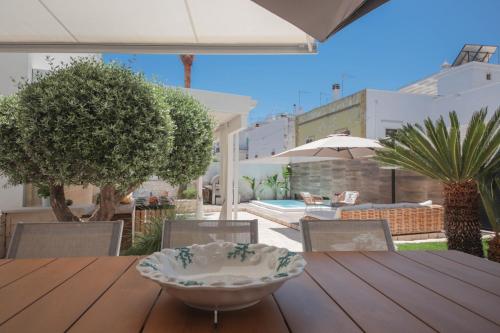 a wooden table with a bowl on top of it at Nilu al Mare - Villa pool & sea Monopoli in Monopoli