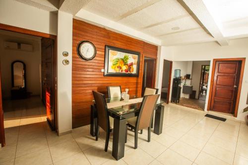 a dining room with a table and chairs and a clock at Playa Lodge in El Valle