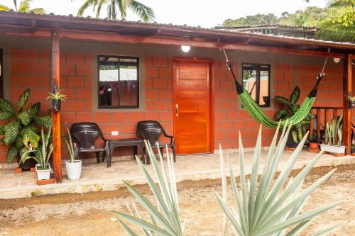 a small red brick house with chairs and a table at Playa Lodge in El Valle