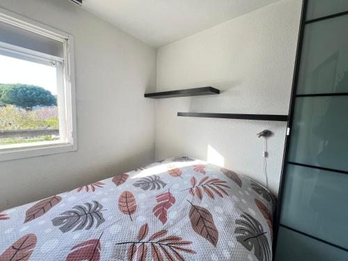- une chambre avec un lit et une couverture à motifs de feuilles dans l'établissement Sol-y-Days Cyprianes pour 4 personnes, résidence avec piscine, à La Grande Motte