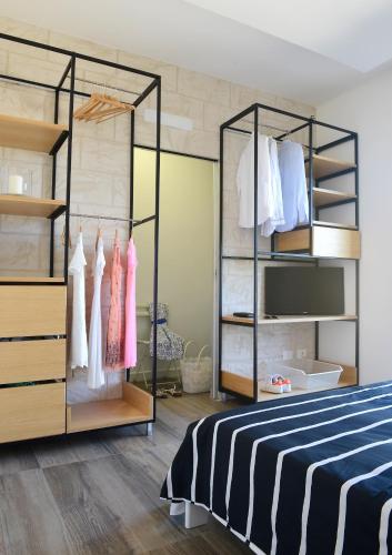 a bedroom with a bed and racks of clothes at Nilu al Mare - Villa pool & sea Monopoli in Monopoli