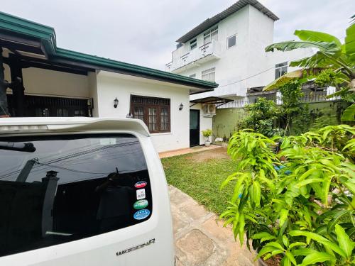 a white car parked in front of a house at Pirivena Garden Resort - AC Units, Kitchen, Attached Bath Room, & WiFi in Boralesgamuwa