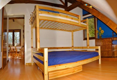 - une chambre avec des lits superposés en bois et des draps bleus dans l'établissement Agréable T2, 700m du pôle thermoludique de Luchon, à Luchon