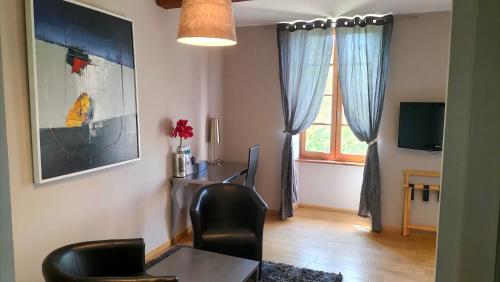 a living room with a desk and a window at Logis Hôtel Château De Palaja in Carcassonne